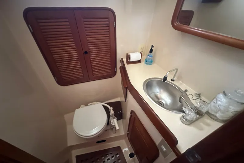 Slide: The Image of Compact bathroom in 1986 Mason 33 yacht with sink, toilet, and wooden accents. - 52
