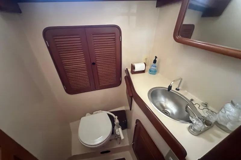 Slide: The Image of Compact bathroom in a 1986 Mason 33 yacht with sink, toilet, and storage. - 53