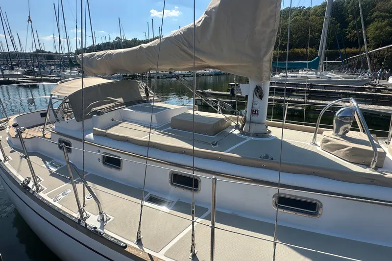 Slide: The Image of Sailboat Mason 33, 1986 model, docked in a marina under clear skies. - 6
