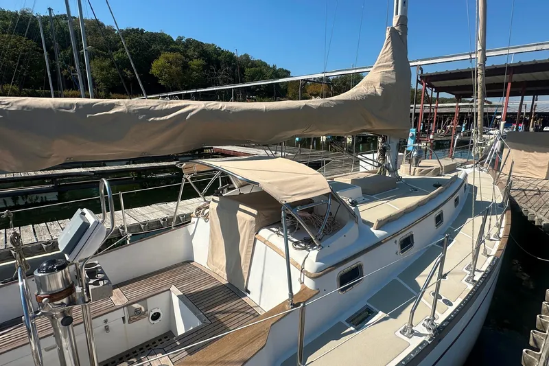 Slide: The Image of Sailboat Mason 33, 1986 model, docked with beige covers and wooden deck. - 9