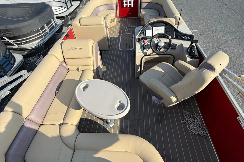 Slide: The Image of 2019 Bentley Pontoons 223 Cruise interior with beige seating and steering console. - 7