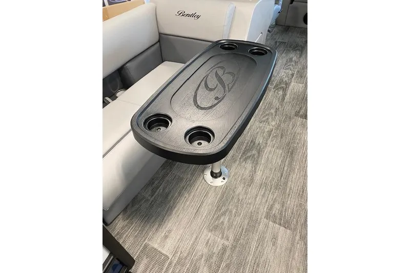 Slide: The Image of 2026 Bentley Pontoons Legacy 243 Swingback interior with gray seating and table. - 3