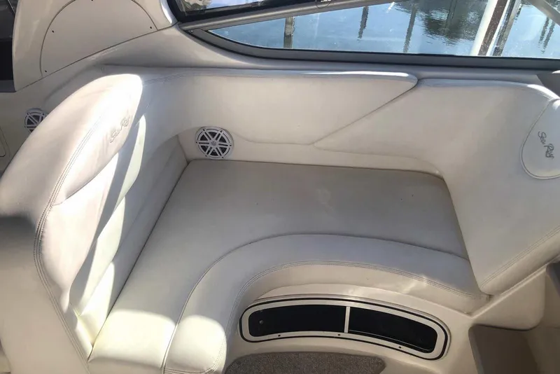 Slide: The Image of 2005 Sea Ray 280 Sundancer interior seating with white upholstery and speaker detail. - 26