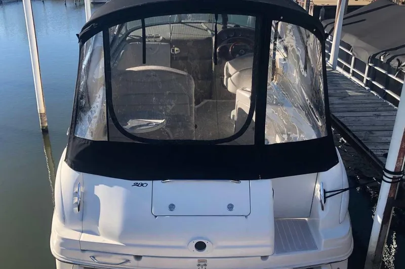 Slide: The Image of 2005 Sea Ray 280 Sundancer boat docked with black canopy and clear windows. - 3