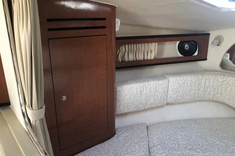 Slide: The Image of 2005 Sea Ray 280 Sundancer cabin interior with wood cabinetry and patterned upholstery. - 34