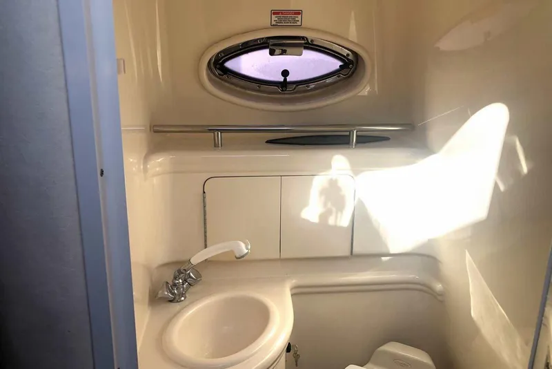 Slide: The Image of 2005 Sea Ray 280 Sundancer bathroom with sink, faucet, and porthole window. - 43