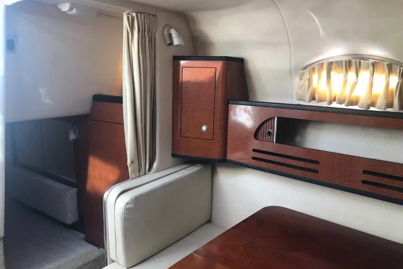 Slide: The Image of Interior of 2005 Sea Ray 280 Sundancer, featuring wood cabinetry and cozy seating area. - 45