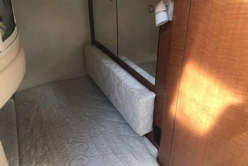 Slide: The Image of Interior cabin of 2005 Sea Ray 280 Sundancer with cushioned bedding and wood paneling. - 46