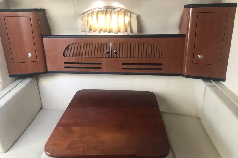 Slide: The Image of 2005 Sea Ray 280 Sundancer cabin interior with wooden cabinets and table. - 49