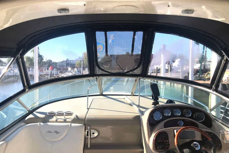 Slide: The Image of 2005 Sea Ray 280 Sundancer cockpit with steering wheel and instrument panel, docked at marina. - 7