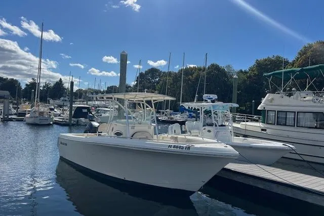Slide: The Image of 2021 Sailfish 242 CC boat docked in a marina under a clear blue sky. - 1