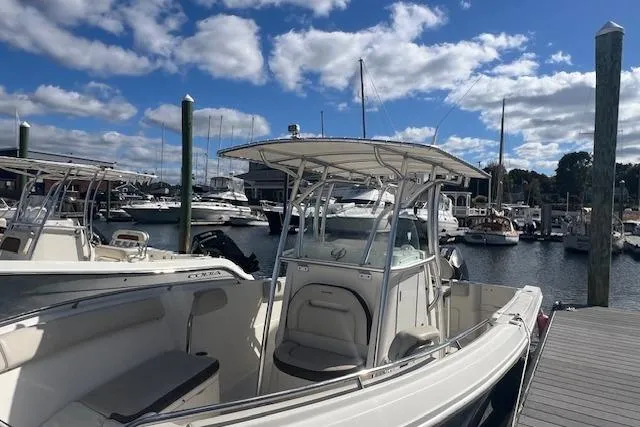 Slide: The Image of 2021 Sailfish 242 CC boat docked at a marina under a blue sky. - 10