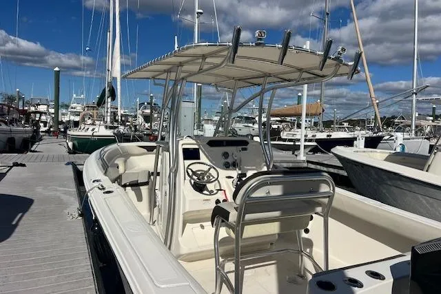 Slide: The Image of 2021 Sailfish 242 CC boat docked at marina under clear blue sky. - 2