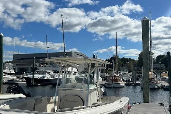 Slide: The Image of 2021 Sailfish 242 CC boat docked at a marina under a partly cloudy sky. - 3