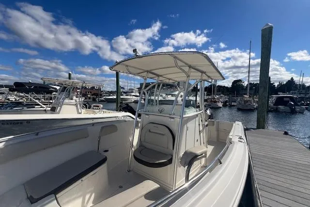Slide: The Image of 2021 Sailfish 242 CC boat docked at marina under blue sky. - 4