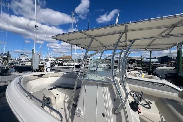 Slide: The Image of 2021 Sailfish 242 CC boat docked at marina under clear blue sky. - 5
