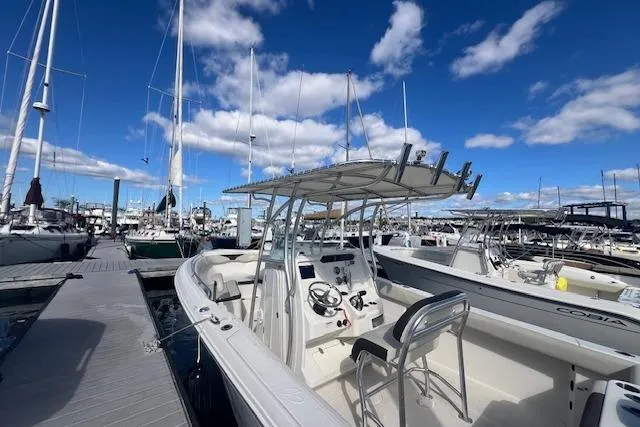 Slide: The Image of 2021 Sailfish 242 CC boat docked at marina under blue sky. - 6