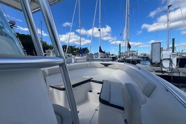 Slide: The Image of 2021 Sailfish 242 CC boat interior at marina, surrounded by sailboats under blue sky. - 8