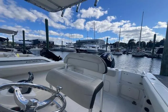 Slide: The Image of 2021 Sailfish 242 CC boat docked at marina under blue sky. - 9