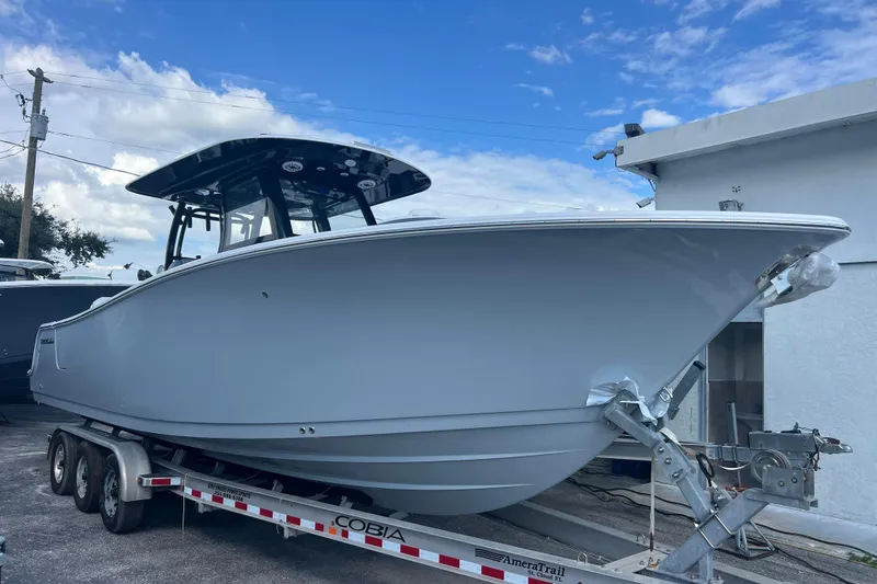 The Image of 2026 Sportsman Open 302 Center Console boat on trailer under blue sky. - 0