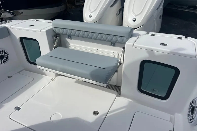 Slide: The Image of 2026 Sportsman Open 302 Center Console boat seating area with cushioned bench and storage compartments. - 18