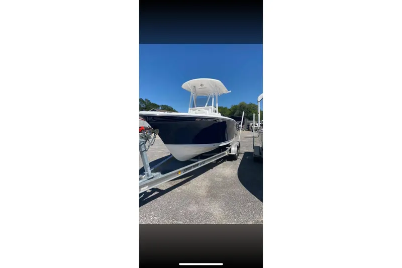 Slide: The Image of 2017 Sea Hunt Ultra 225 boat on dry dock with other boats in background. - 1