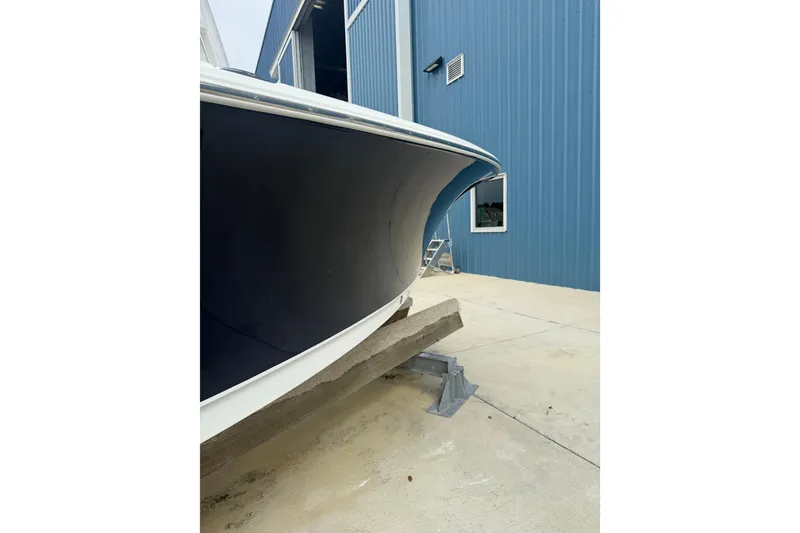 Slide: The Image of 2017 Sea Hunt Ultra 225 boat on trailer, parked outdoors under clear blue sky. - 14