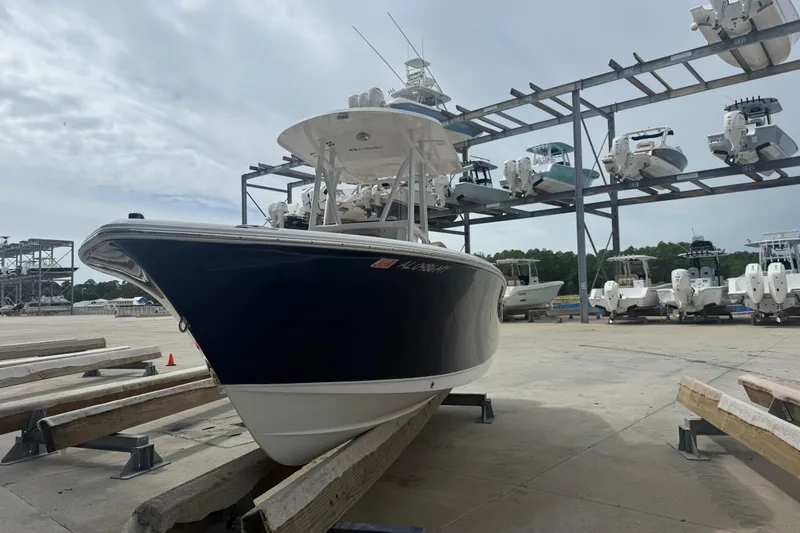 Slide: The Image of 2017 Sea Hunt Ultra 225 boat interior with brown seating, near blue building. - 4