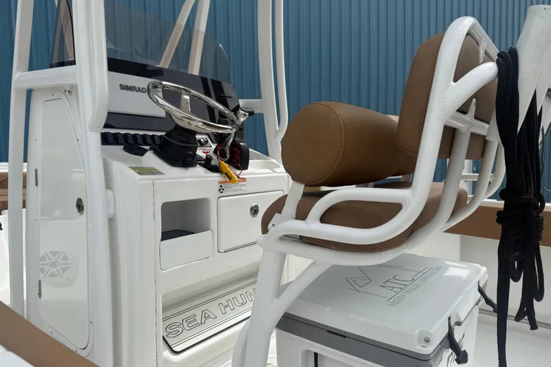 Slide: The Image of 2017 Sea Hunt Ultra 225 boat interior with tan seating, docked with other boats. - 5