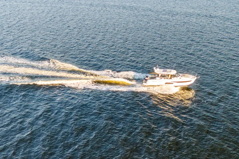 Slide: The Image of Aerial view of 2021 Jeanneau NC 1095 cruising on open water. - 13