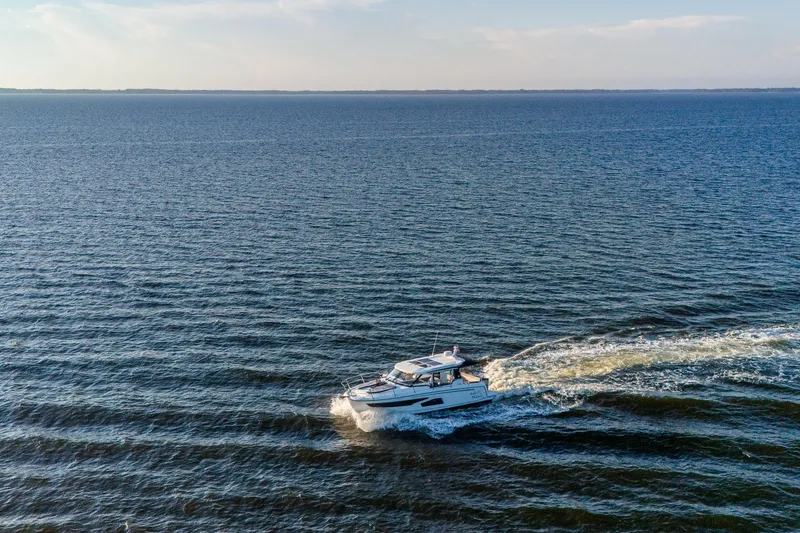 Slide: The Image of 2021 Jeanneau NC 1095 cruising on open water under a clear sky. - 24