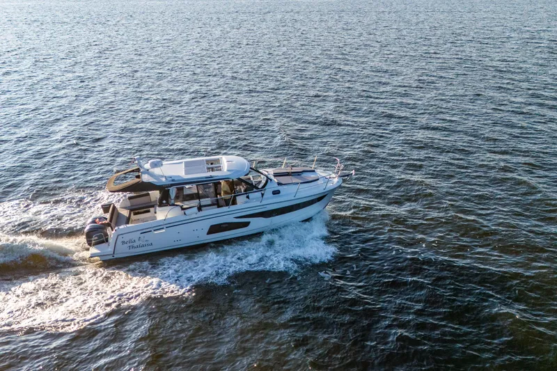 Slide: The Image of 2021 Jeanneau NC 1095 motor yacht cruising on open water. - 25