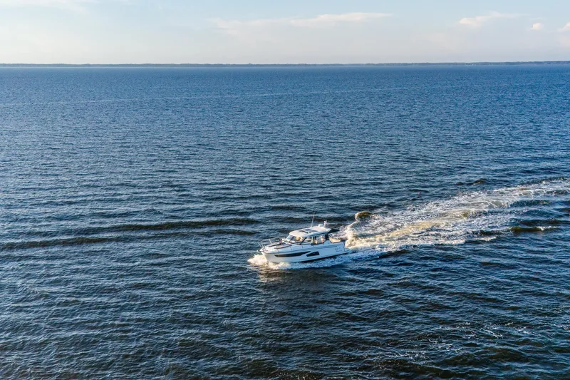 Slide: The Image of 2021 Jeanneau NC 1095 cruising on open water under a clear sky. - 26