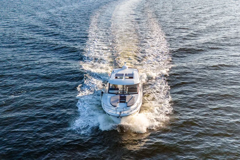 Slide: The Image of 2021 Jeanneau NC 1095 motorboat cruising on open water, aerial view. - 28