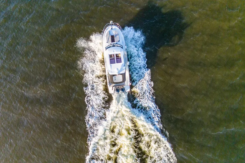 Slide: The Image of Aerial view of 2021 Jeanneau NC 1095 motorboat cruising on open water. - 31