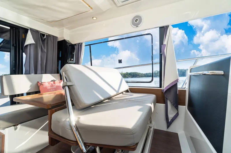 Slide: The Image of Interior of 2021 Jeanneau NC 1095 boat with seating and table, overlooking water. - 39