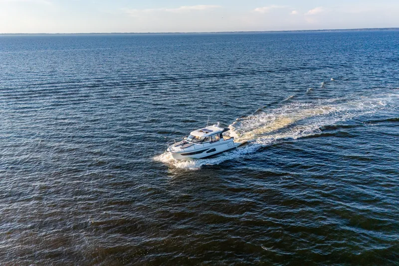 Slide: The Image of 2021 Jeanneau NC 1095 cruising on open water under a clear sky. - 5