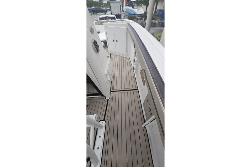 Slide: The Image of 2022 Yamaha Boats 255 FSH Sport E deck with sleek design and wood finish. - 2