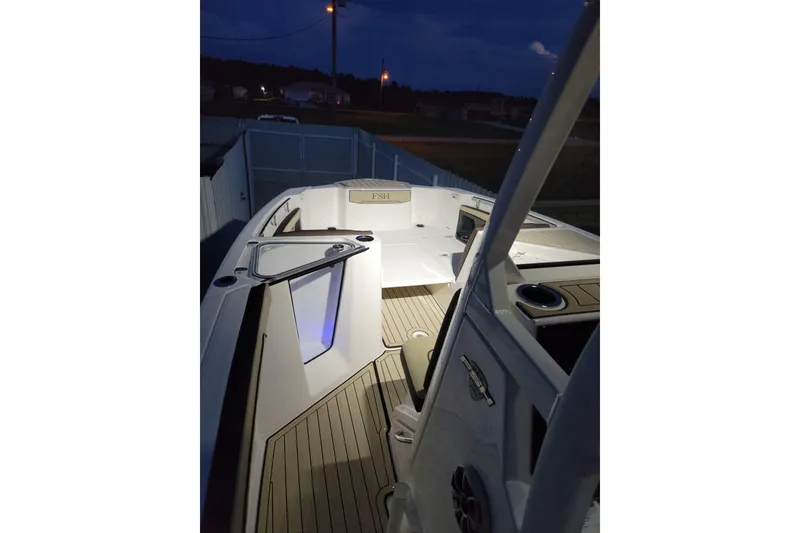 Slide: The Image of 2022 Yamaha Boats 255 FSH Sport E interior at night, featuring sleek design and ambient lighting. - 4