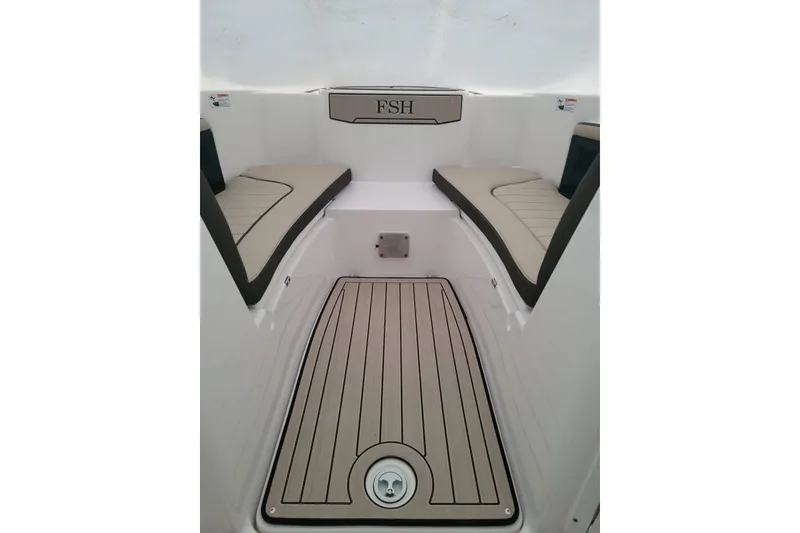Slide: The Image of 2022 Yamaha Boats 255 FSH Sport E interior with cushioned seating and teak-style flooring. - 7