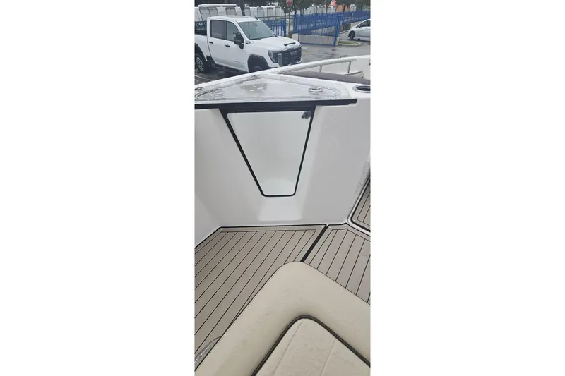 Slide: The Image of 2022 Yamaha Boats 255 FSH Sport E interior with sleek design and wood-textured flooring. - 8
