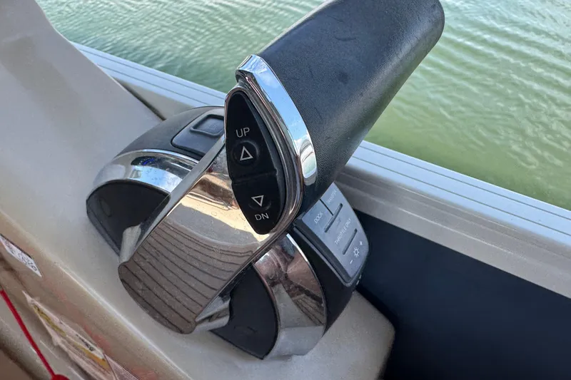 Slide: The Image of Throttle control lever on a 2017 Regency 254 LE3 boat, near water. - 12