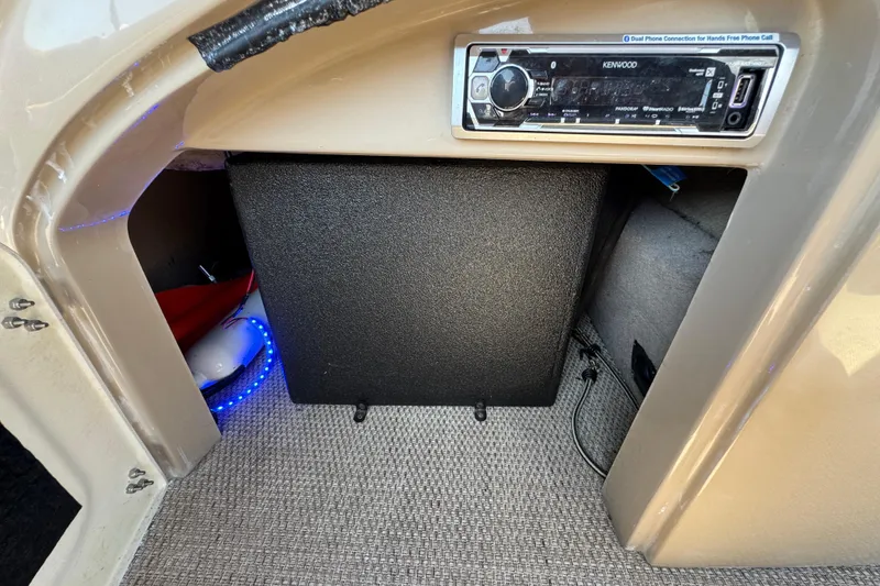 Slide: The Image of 2017 Regency 254 LE3 boat interior with Kenwood stereo system and storage compartment. - 20