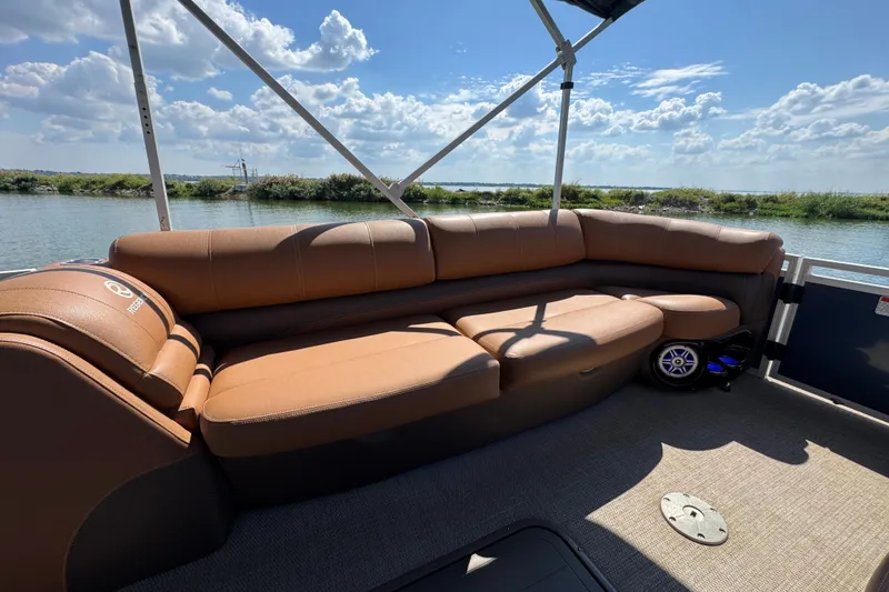 Slide: The Image of 2017 Regency 254 LE3 pontoon boat with brown seating, on a sunny day by the water. - 7