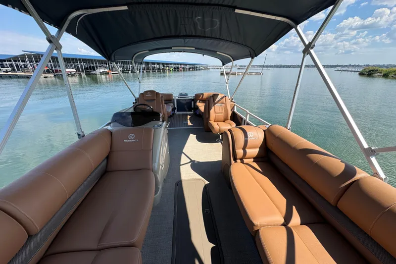 Slide: The Image of 2017 Regency 254 LE3 pontoon boat with tan seating, docked on a sunny day. - 9