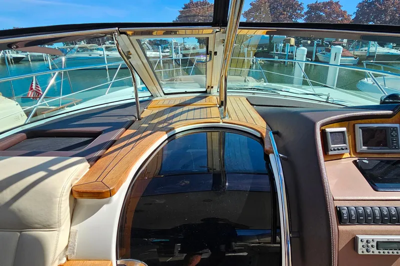 Slide: The Image of 2009 Cobalt 373 yacht interior with wooden dashboard and marina view. - 26