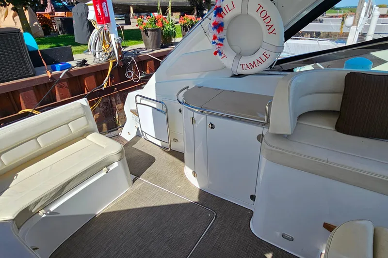 Slide: The Image of 2009 Cobalt 373 boat interior with seating and life preserver, docked near garden. - 30