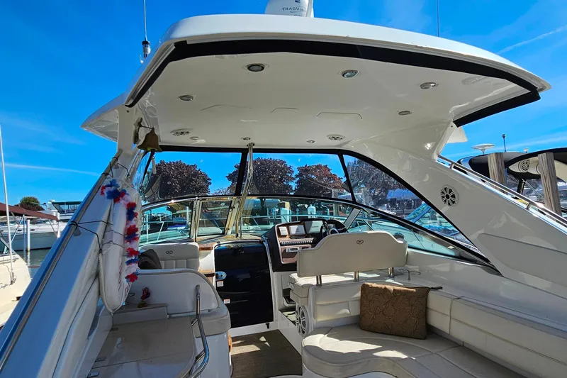 Slide: The Image of 2009 Cobalt 373 boat interior with seating and dashboard, docked under clear blue sky. - 32