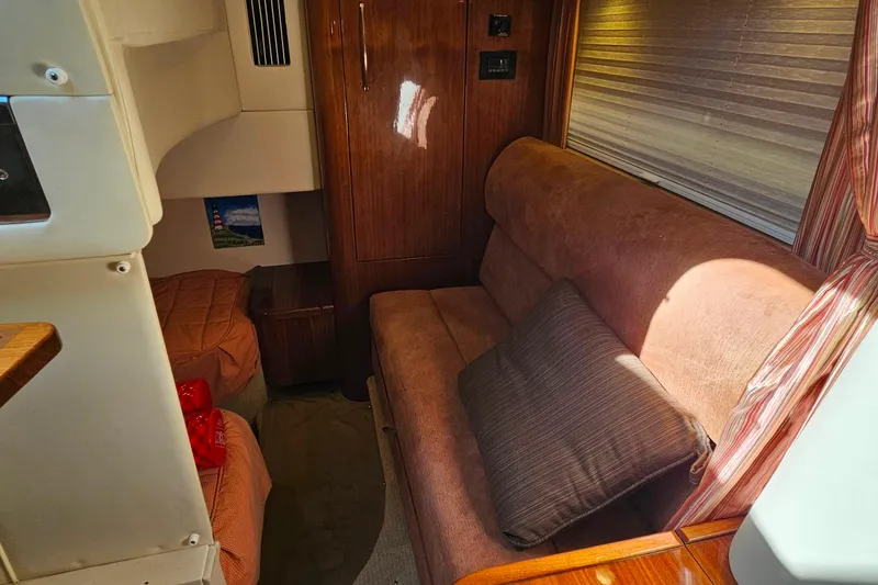 Slide: The Image of Interior of a 2009 Cobalt 373 boat featuring a cozy seating area and wooden cabinetry. - 41