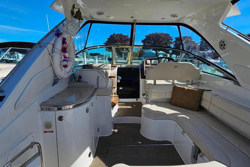 Slide: The Image of Interior of a 2009 Cobalt 373 boat with white seating and a steering area. - 9
